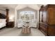 This bedroom features a sitting area, bright windows, and dark wood furniture at 6772 Tiger Tooth, Littleton, CO 80124