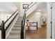 Entryway boasts hardwood floors, a staircase with dark wood trim, and a view into the living room at 6772 Tiger Tooth, Littleton, CO 80124