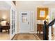 Foyer includes a decorative front door, a hardwood floor rug, and an antique table with a gilded mirror at 6772 Tiger Tooth, Littleton, CO 80124