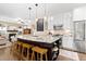 Spacious kitchen with granite island, bar stool seating, white cabinets, and stainless steel appliances at 6772 Tiger Tooth, Littleton, CO 80124