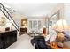 Bright living room features neutral walls, light carpet, stylish furniture, and abundant natural light through window shutters at 6772 Tiger Tooth, Littleton, CO 80124