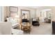 Bright living room features neutral walls, light carpet, stylish furniture, and abundant natural light through window shutters at 6772 Tiger Tooth, Littleton, CO 80124