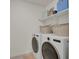 Organized laundry room with white shelving and front load washer and dryer at 24555 E Ohio Dr, Aurora, CO 80018