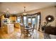 Cozy dining area featuring hardwood floors, and a bay window with scenic views, adjacent to the kitchen at 10520 W Vassar Dr, Lakewood, CO 80227