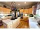 Bright kitchen featuring wooden cabinets, stainless steel appliances, a kitchen island, and hardwood floors at 10520 W Vassar Dr, Lakewood, CO 80227