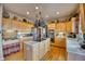 Spacious kitchen with light wood cabinets, stainless steel appliances, and a center island with a cooktop at 10520 W Vassar Dr, Lakewood, CO 80227