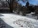 This fenced backyard is snow-covered and leads to carports at 6029 S Sycamore St, Littleton, CO 80120