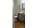 Bathroom featuring laminate floors, modern fixtures, a toilet, and plenty of storage space at 6029 S Sycamore St, Littleton, CO 80120