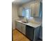 A well-lit kitchen with new light-grey cabinets, modern countertops, and hardwood floors at 6029 S Sycamore St, Littleton, CO 80120