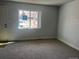 Bright living room featuring neutral walls, carpet, and a large window at 6029 S Sycamore St, Littleton, CO 80120