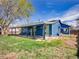 Spacious backyard with a covered patio, green lawn, and a chain link fence at 4269 Freeport Way, Denver, CO 80239
