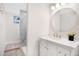 Basement bathroom with white vanity, marble shower, and round mirror at 7204 W 26Th Ave, Lakewood, CO 80214