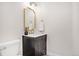 Elegant powder room with dark vanity, gold accents, and marble countertop at 7204 W 26Th Ave, Lakewood, CO 80214