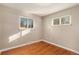 Sunny bedroom featuring hardwood flooring, neutral walls and multiple windows with sun-filled views at 406 Titan Ct, Aurora, CO 80011