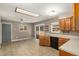 Eat-in kitchen features oak cabinetry, tile floors, skylight, and stainless steel sink at 406 Titan Ct, Aurora, CO 80011