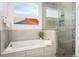 Spa-like bathroom showcasing a soaking tub and a glass-enclosed shower with built-in shelves at 2114 Lowell Blvd, Denver, CO 80211