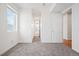 Open bedroom with plush carpeting, large window, and access to the ensuite bathroom and hallway at 2114 Lowell Blvd, Denver, CO 80211