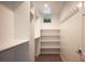 Bright walk-in closet with adjustable shelving and a row of hooks for optimal storage solutions at 2114 Lowell Blvd, Denver, CO 80211