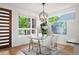 Bright dining room with modern light fixture, glass table and a view to the exterior at 2114 Lowell Blvd, Denver, CO 80211