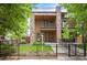 Contemporary multi-story home with stone accents, a balcony, manicured lawn and a black metal fence at 2114 Lowell Blvd, Denver, CO 80211
