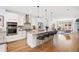 Open-concept kitchen with white cabinetry, stainless steel appliances, and a center island with bar stools at 2114 Lowell Blvd, Denver, CO 80211