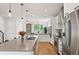 Bright kitchen featuring an island with seating, stainless steel appliances, and hardwood floors at 2114 Lowell Blvd, Denver, CO 80211