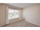 Carpeted bedroom with large window and neutral color palette, offering a peaceful and inviting atmosphere at 12225 W 57Th Pl, Arvada, CO 80002