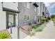 Modern townhome exterior with covered entry, address number, and rock garden at 12225 W 57Th Pl, Arvada, CO 80002
