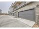 A view of the garages for the townhome community, with modern gray doors and light brown siding at 12225 W 57Th Pl, Arvada, CO 80002
