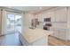 Modern kitchen with stainless steel appliances, gray cabinets, island, and large sliding glass doors at 12225 W 57Th Pl, Arvada, CO 80002
