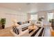 Bright living room with stylish decor, light wood floors, and modern striped rug at 12225 W 57Th Pl, Arvada, CO 80002
