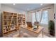 Bright office with open wood shelving, and a white and wood writing desk at 12225 W 57Th Pl, Arvada, CO 80002