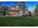 Expansive backyard featuring a covered patio, lush green lawn, and mature landscaping at 3566 E Meadow Creek Pl, Highlands Ranch, CO 80126