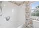 Bright bathroom featuring white tiled walls, floral wallpaper, and a shower-tub combination at 3566 E Meadow Creek Pl, Highlands Ranch, CO 80126