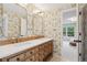 Spacious bathroom with double sink vanity, decorative wallpaper, and doorway to bedroom at 3566 E Meadow Creek Pl, Highlands Ranch, CO 80126