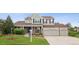 Charming two-story home with a well-manicured front yard, mature trees, and a three car garage at 3566 E Meadow Creek Pl, Highlands Ranch, CO 80126