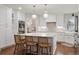 Bright kitchen with white cabinetry, stainless steel appliances, a large island, and wood floors at 3566 E Meadow Creek Pl, Highlands Ranch, CO 80126