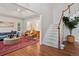 Bright living room with hardwood floors, stylish furniture, and staircase leading to the upper level at 3566 E Meadow Creek Pl, Highlands Ranch, CO 80126