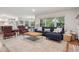 Open-concept living room with comfortable seating, a fireplace, large windows, and a view of the dining area at 3566 E Meadow Creek Pl, Highlands Ranch, CO 80126