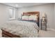 Cozy bedroom with a wooden headboard, bedside lamps, and a neutral-toned patterned comforter set at 3566 E Meadow Creek Pl, Highlands Ranch, CO 80126