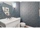 Charming powder room with patterned wallpaper, white vanity, and round mirror at 3566 E Meadow Creek Pl, Highlands Ranch, CO 80126