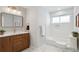 Modern bathroom with warm wood vanity, shower with tub, and elegant fixtures at 2784 E Maplewood Ave, Centennial, CO 80121