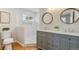 Bathroom featuring a walk-in shower, double sinks, and wood-framed mirrors at 2784 E Maplewood Ave, Centennial, CO 80121