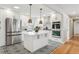 Modern white kitchen with stainless steel appliances, an island with a white countertop, and decorative pendant lighting at 2784 E Maplewood Ave, Centennial, CO 80121