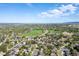 Aerial view features lush green neighborhood, lake, and distant mountains on a sunny day at 4290 S Deframe St, Morrison, CO 80465
