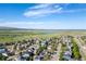 Aerial view features a lush green neighborhood, lake, and distant mountains on a sunny day at 4290 S Deframe St, Morrison, CO 80465