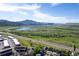 Aerial view of a suburban neighborhood with mountain views, lake, and walking trails at 4290 S Deframe St, Morrison, CO 80465