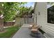Cozy backyard deck with wicker rocking chairs and a table, surrounded by lush greenery and mature trees at 4290 S Deframe St, Morrison, CO 80465