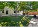 Spacious backyard with artificial lawn, mature trees, and a patio area perfect for outdoor entertaining at 4290 S Deframe St, Morrison, CO 80465