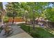 Landscaped backyard with a deck, artificial turf, and mature trees at 4290 S Deframe St, Morrison, CO 80465